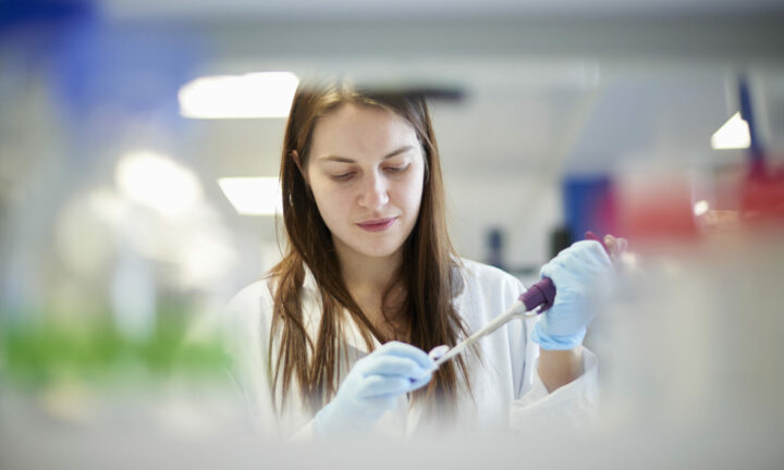 Female science student pipetting in laboratory